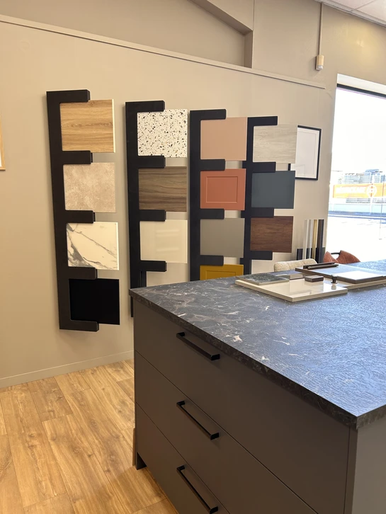 Showroom d'une cuisine extérieure avec meuble bas suspendu laqué taupe, plan de travail en inox, évier intégré et robinet monotrou